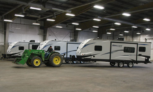 Man moving large RV with a large tractor